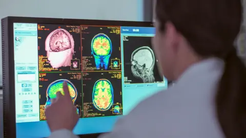 Monty Rakusen/Getty Female doctor looking at MRI scanner monitor 