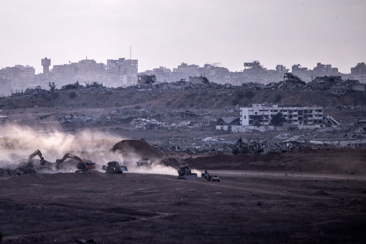 Israeli tanks and military vehicles are seen deployed with some military vehicles, helicopters, and drones patrolling along the border region following the implementation of the ceasefire between Israel and Hamas in Gaza and the withdrawal of Israeli forces inside the yellow line in Sderot, Israel on October 14, 2025. [Mostafa Alkharouf - Anadolu Agency]