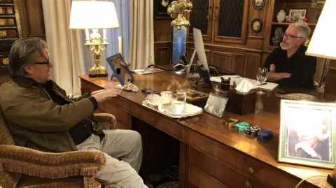 House Oversight Committee Steve Bannon sitting at an ornate desk across from Jeffrey Epstein in a fancy office room 